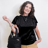 Woman holding a black handbag against a white background