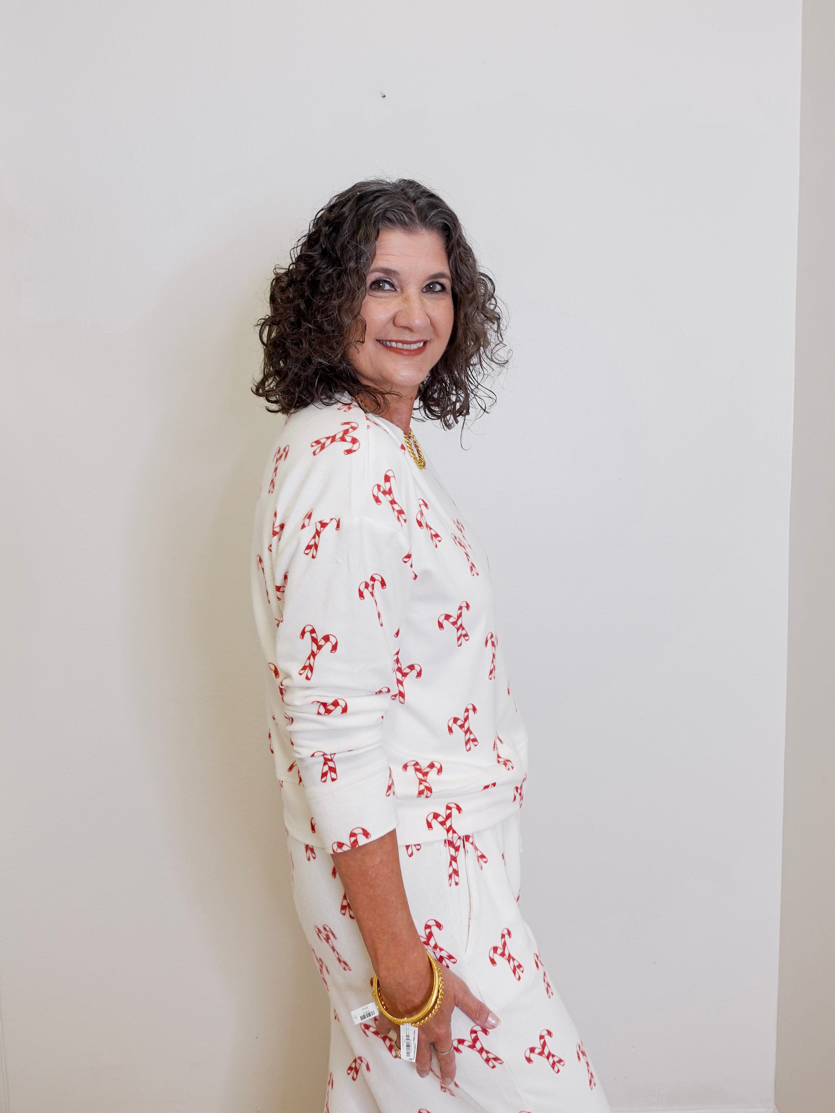Woman wearing a white floral dress against a plain background