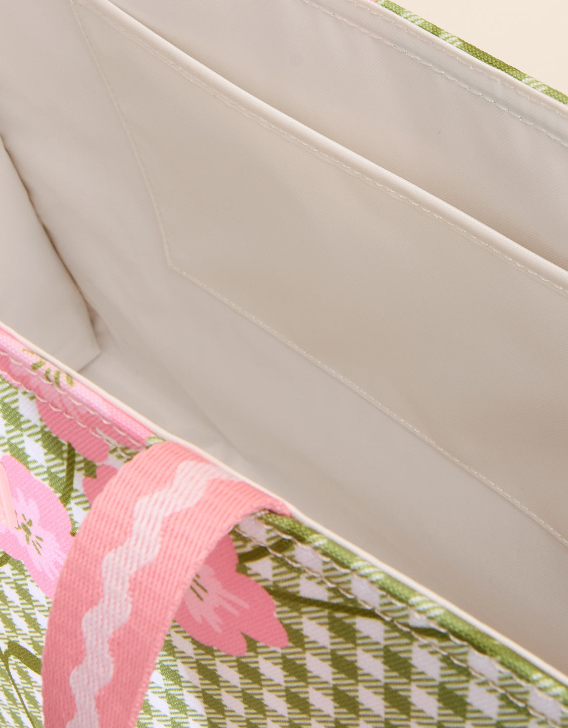 Close-up of a pink floral-patterned product on a beige surface