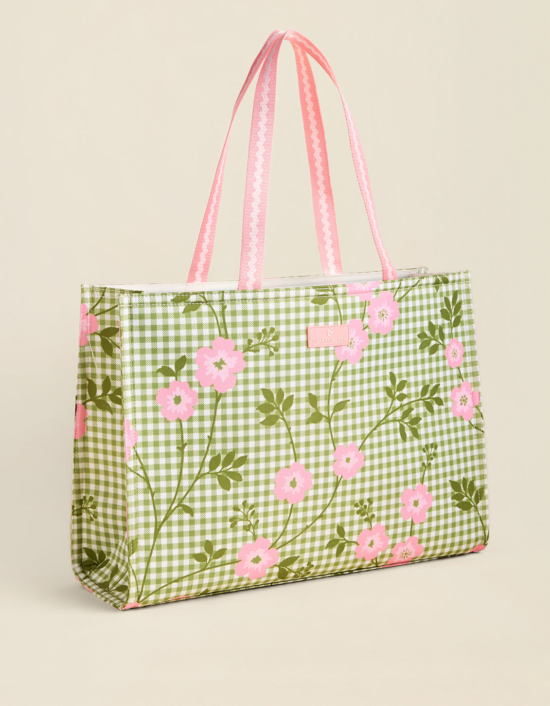 Green gingham tote bag with pink floral pattern on a beige background