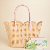 Woven handbag with pink handles on a beige background