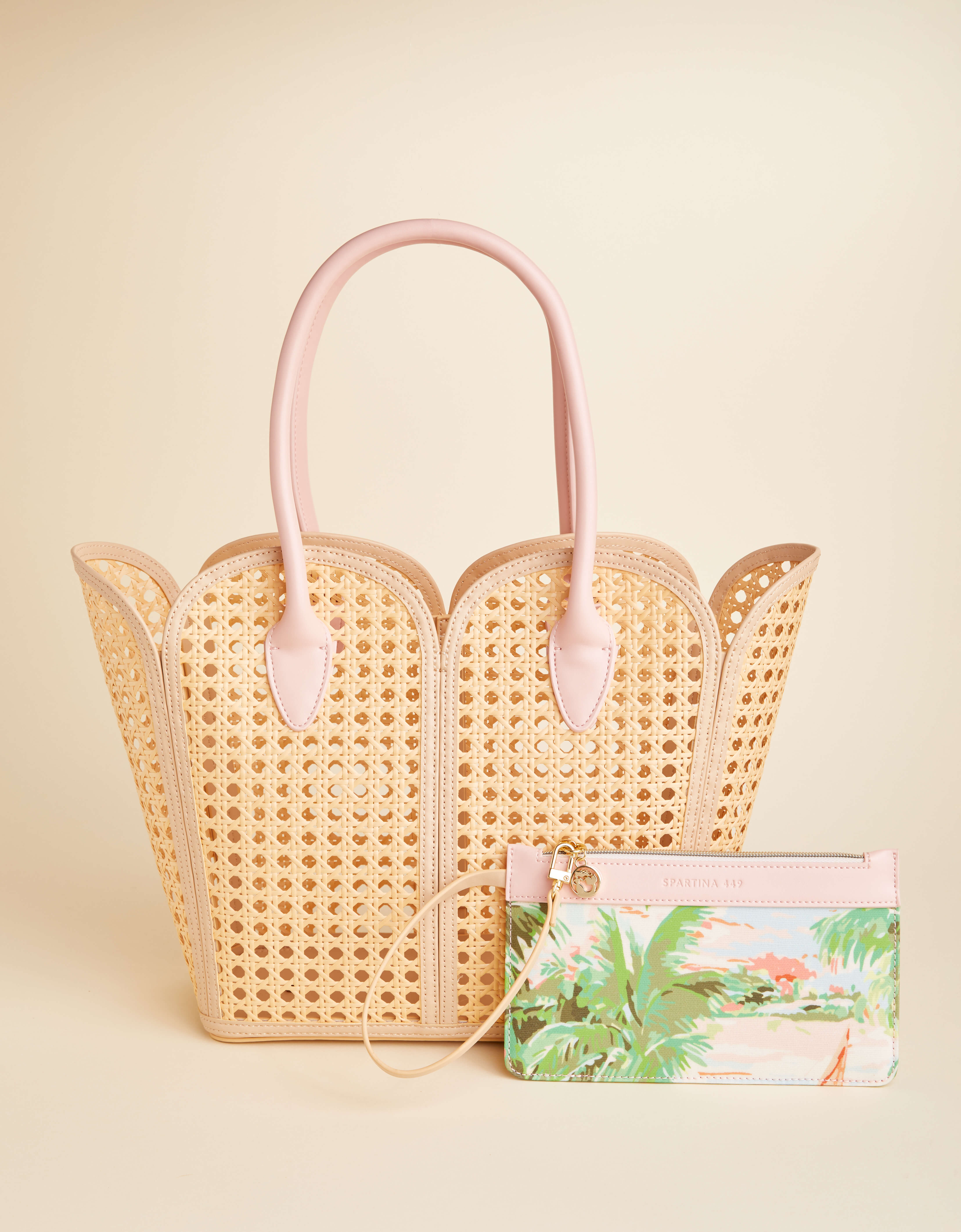 Woven handbag with pink handles on a beige background