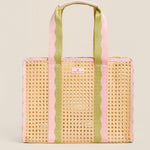 Woven tote bag with pink and green striped handles on a beige background