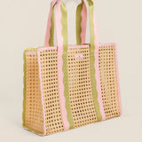Woven tote bag with pink and green striped handles on a beige background