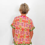 Person wearing a colorful patterned shirt with a white background