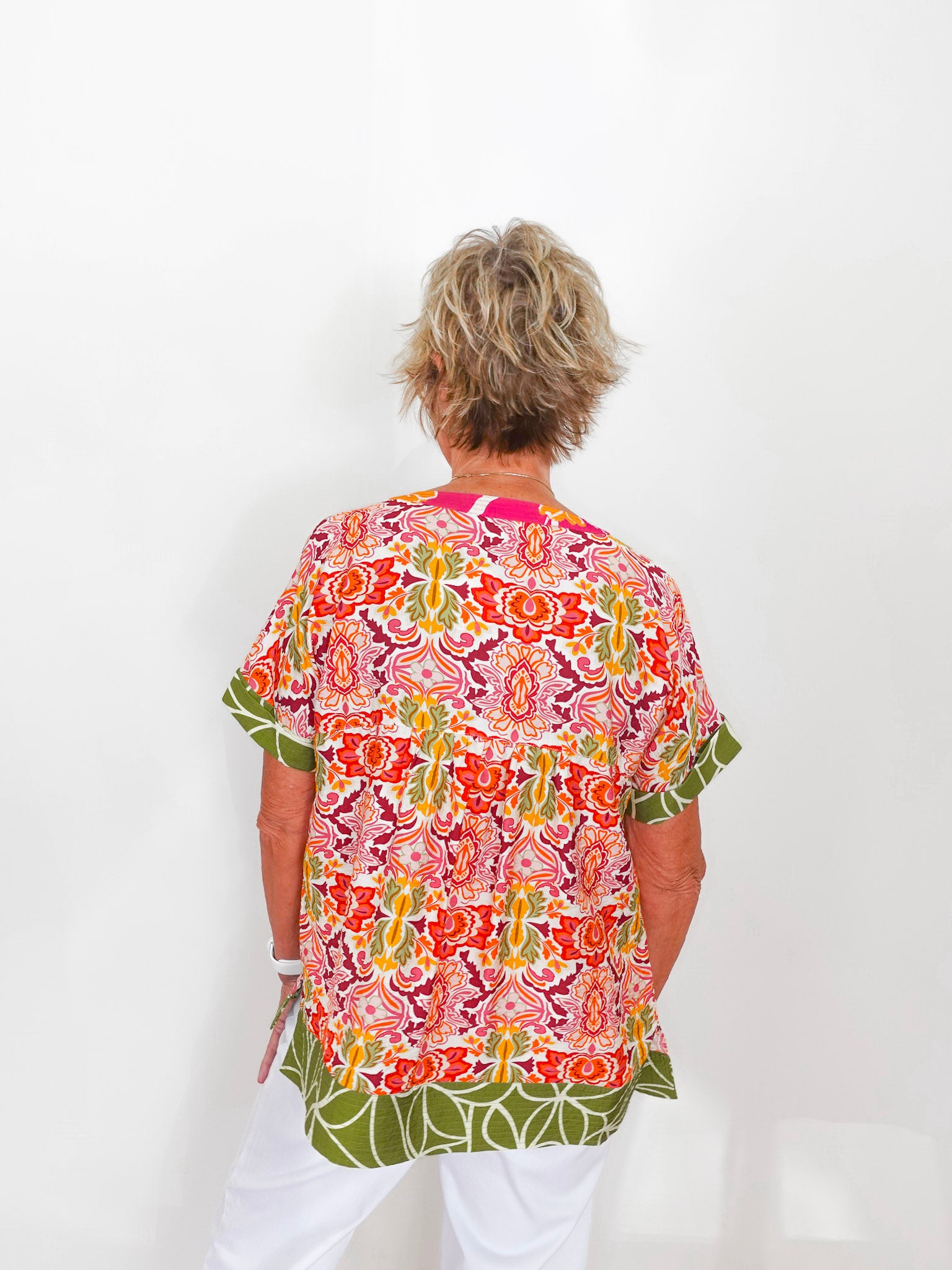 Person wearing a colorful patterned shirt with a white background
