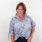 Woman wearing a floral blouse with a plain background