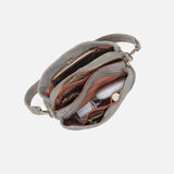 Gray handbag with a white interior, containing a white electronic device and brown pouch.