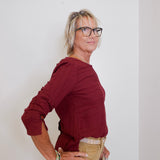 Person wearing a red shirt and beige pants against a white background