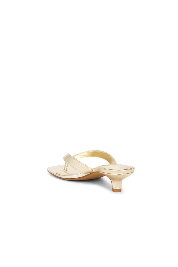 Gold high-heeled sandal on a white background