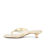 Gold high-heeled sandal on a white background
