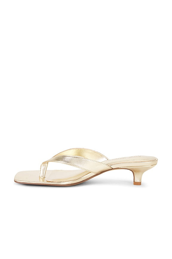 Gold high-heeled sandal on a white background