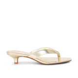 Gold high-heeled sandal on a white background