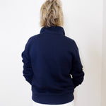 Person wearing a navy blue jacket against a white background