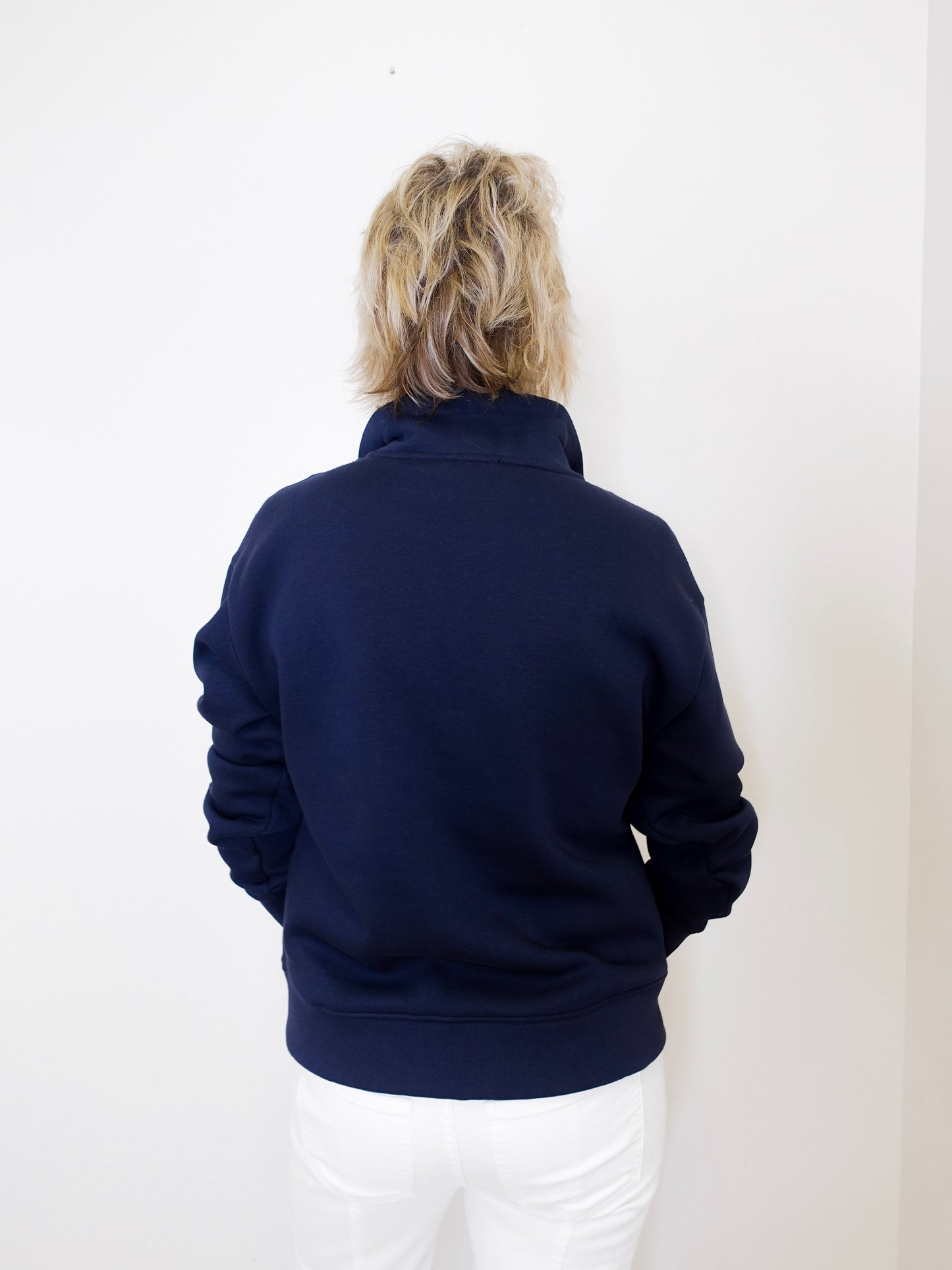 Person wearing a navy blue jacket against a white background
