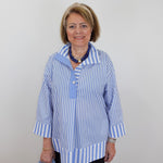 Woman wearing a blue and white striped shirt with a plain background