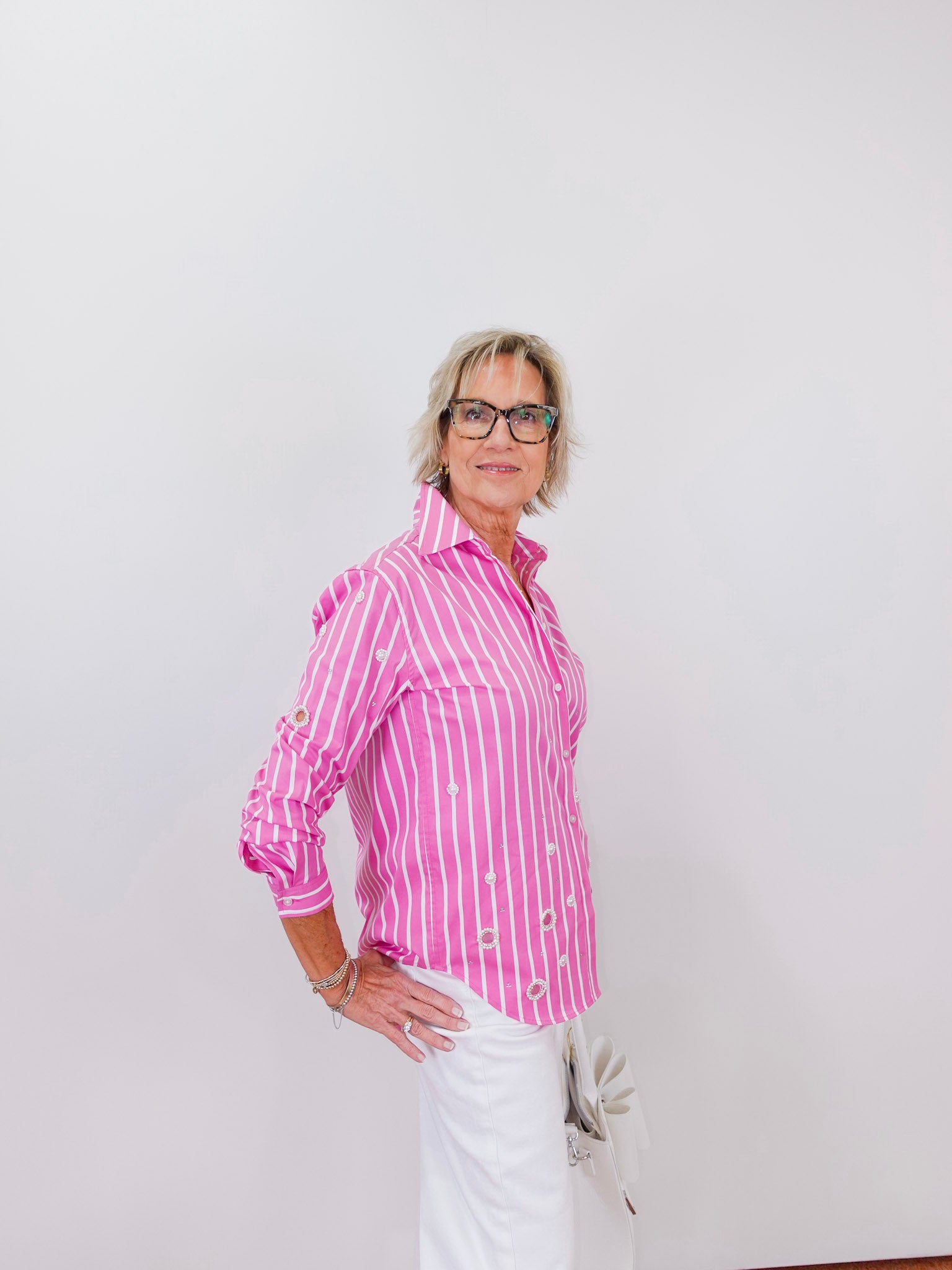 Woman wearing a pink striped shirt against a white background