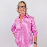 Person wearing a pink and white striped shirt against a plain background
