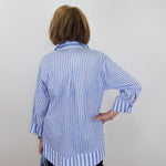 Person wearing a blue and white striped shirt against a plain background