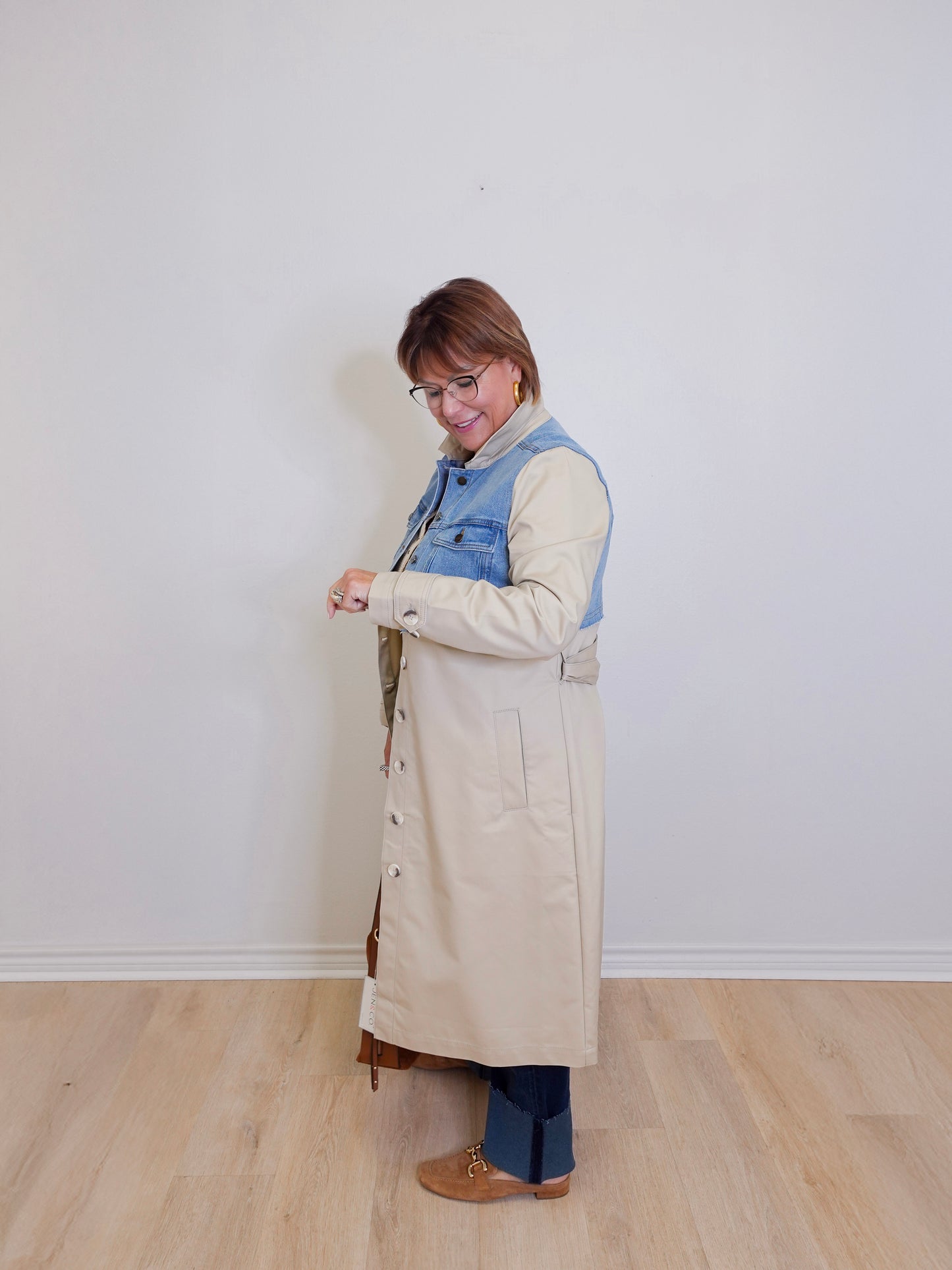 woman wearing a stylish denim mix trench coat against white background 