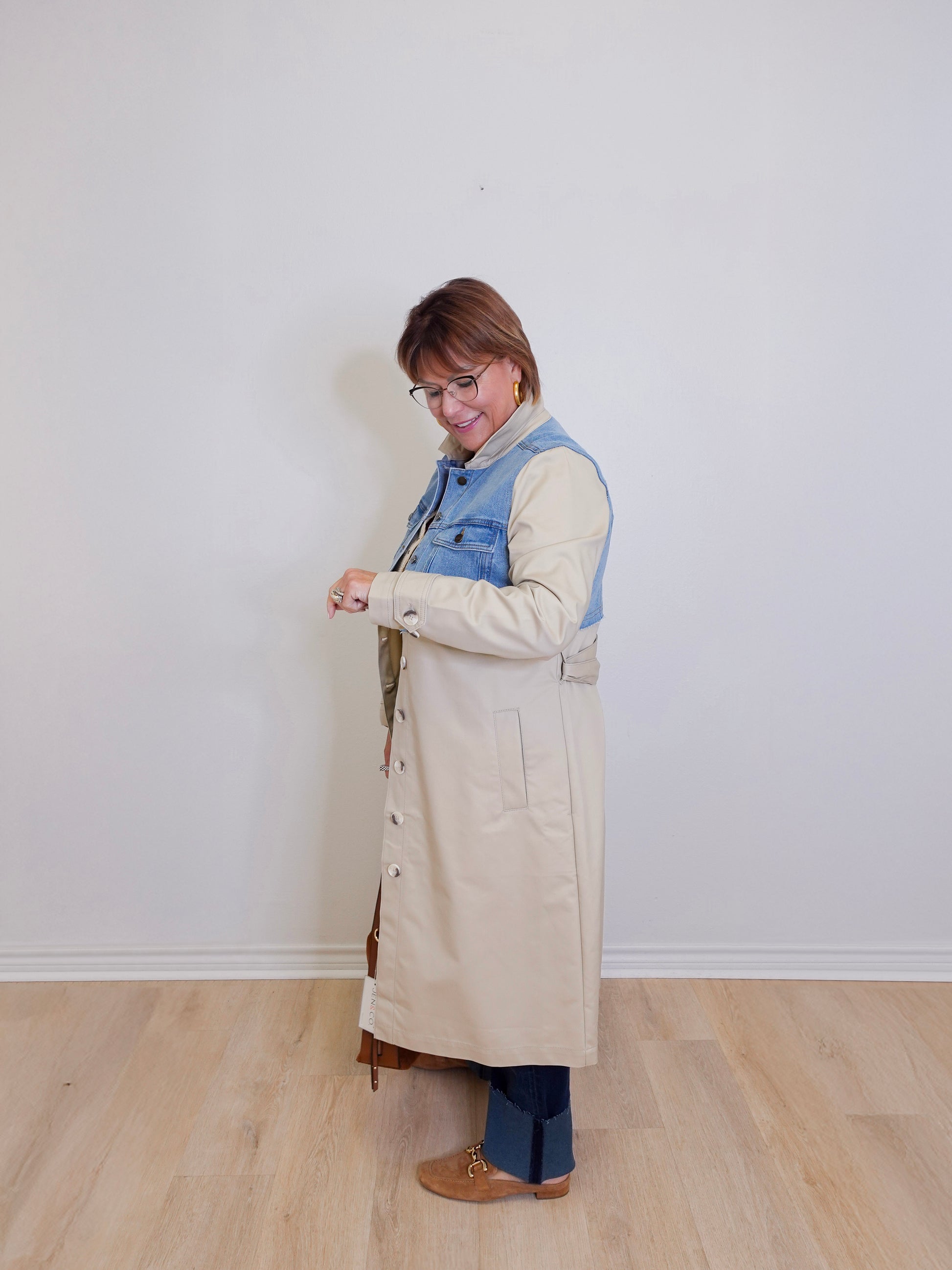 woman wearing a stylish denim mix trench coat against white background 