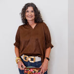 Woman holding a floral clutch against a white background