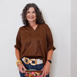 Woman holding a floral clutch against a white background