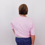 Person wearing a pink shirt and blue jeans from behind on a white background