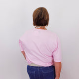 Person wearing a pink shirt and blue jeans from behind on a white background