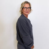 Person wearing a dark gray outfit against a white background