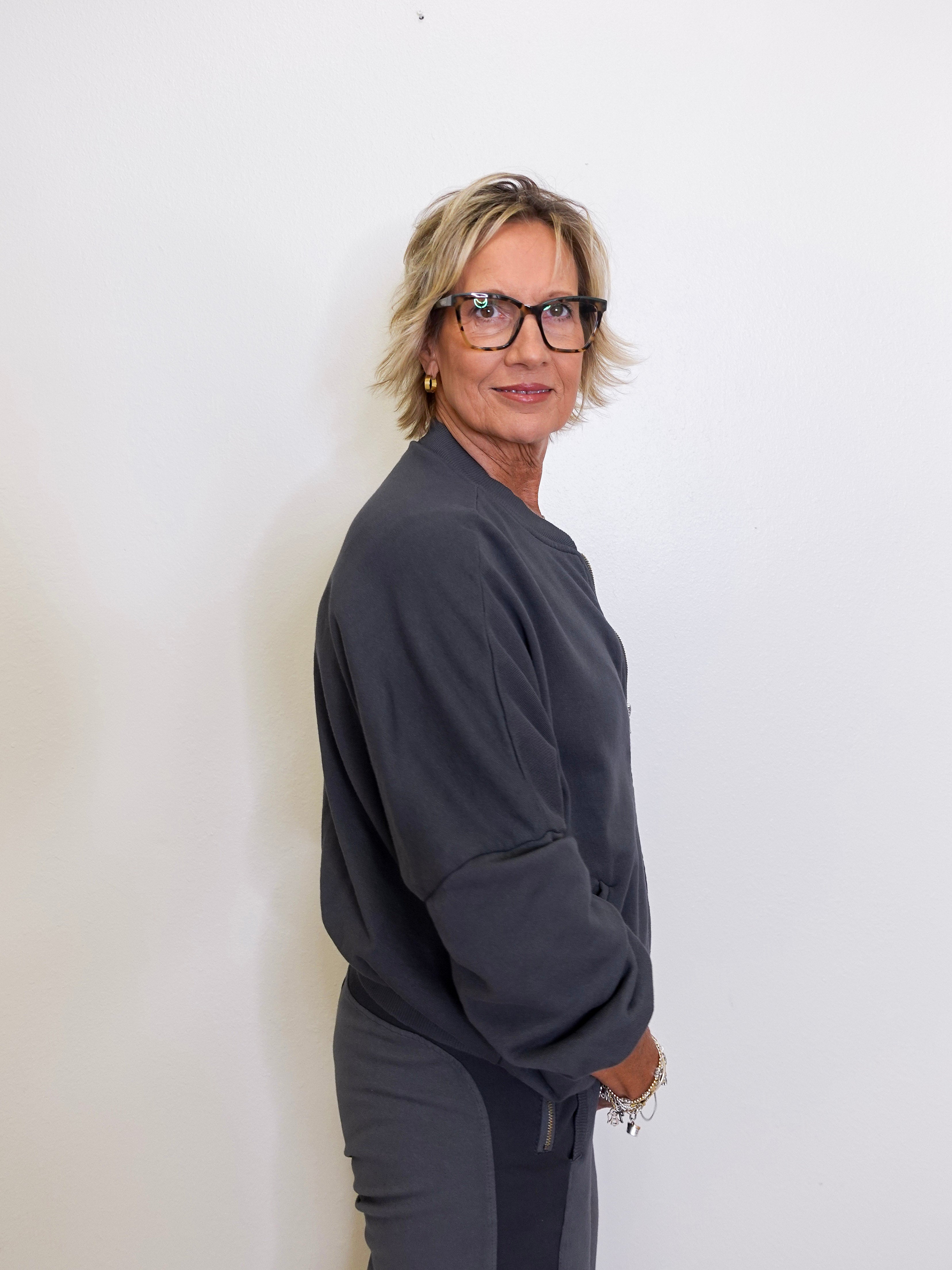 Person wearing a dark gray outfit against a white background