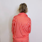 Person wearing a red and white striped outfit against a plain background