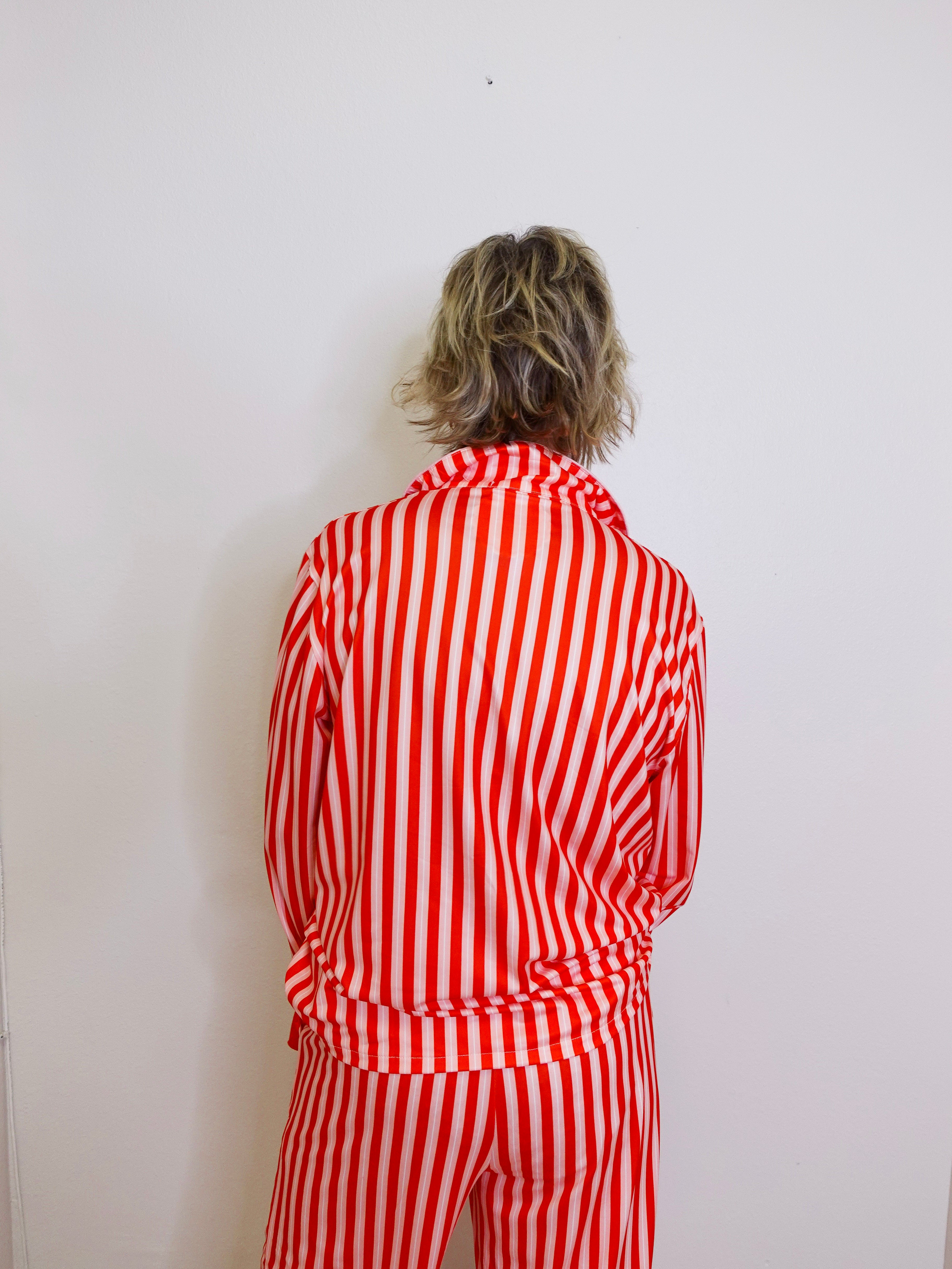 Person wearing a red and white striped outfit against a plain background