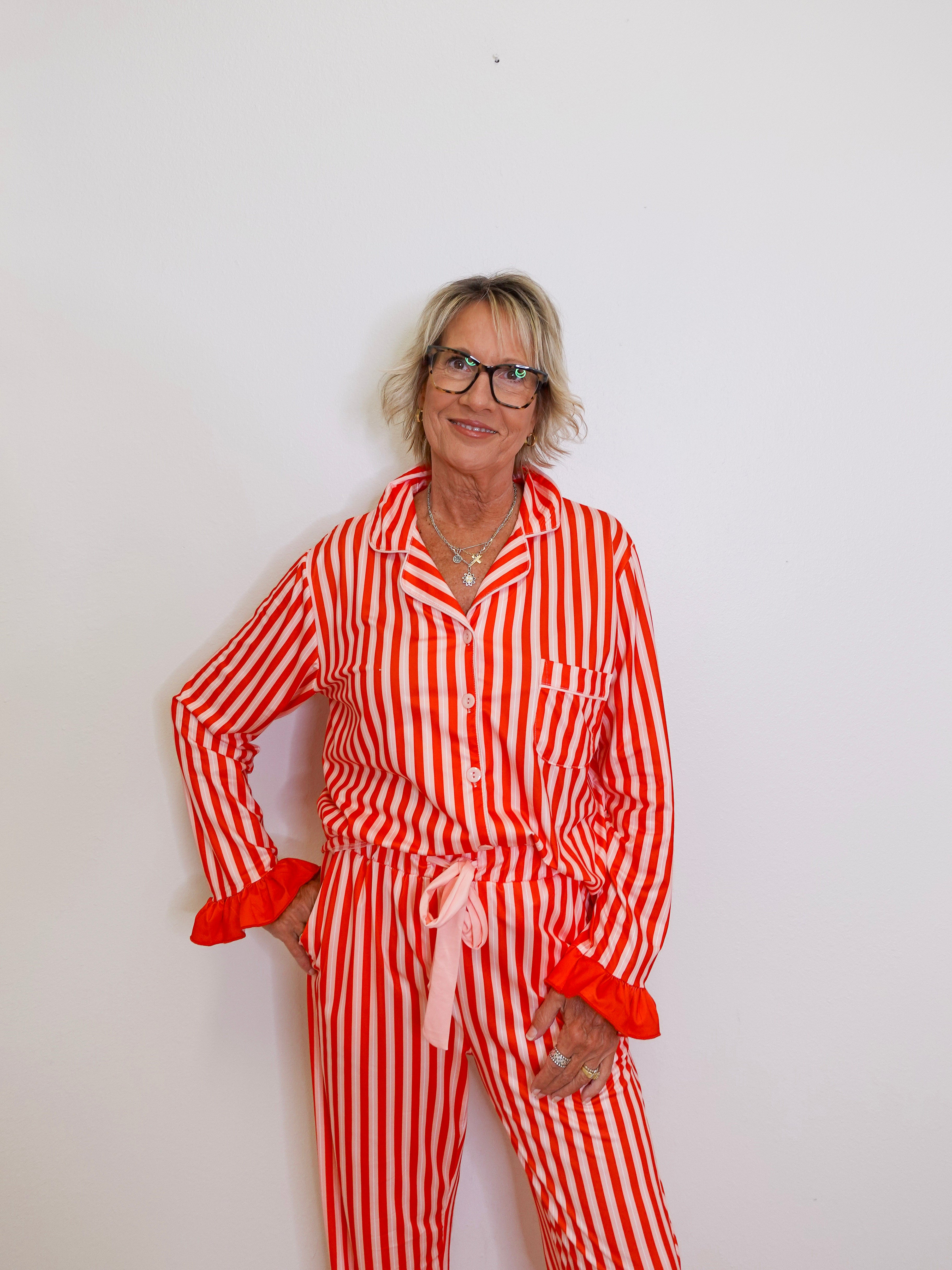 Person wearing a red and white striped pajama set against a plain background