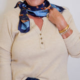 woman wearing a tan waffle knit top that is long sleeve in front of a white background. 