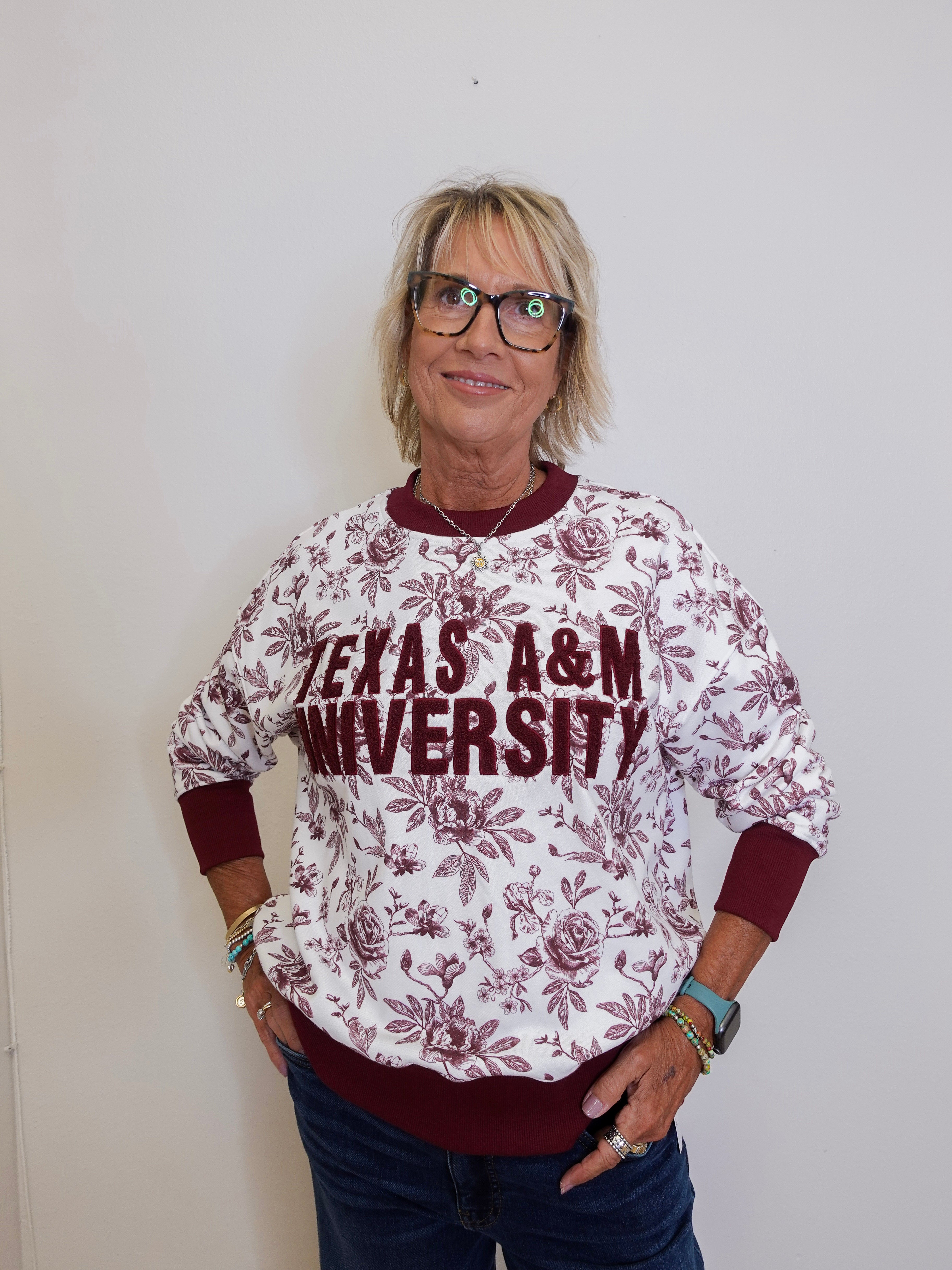 Person wearing a Texas A&M University sweatshirt against a plain background
