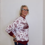 Person wearing a patterned shirt with text against a plain background