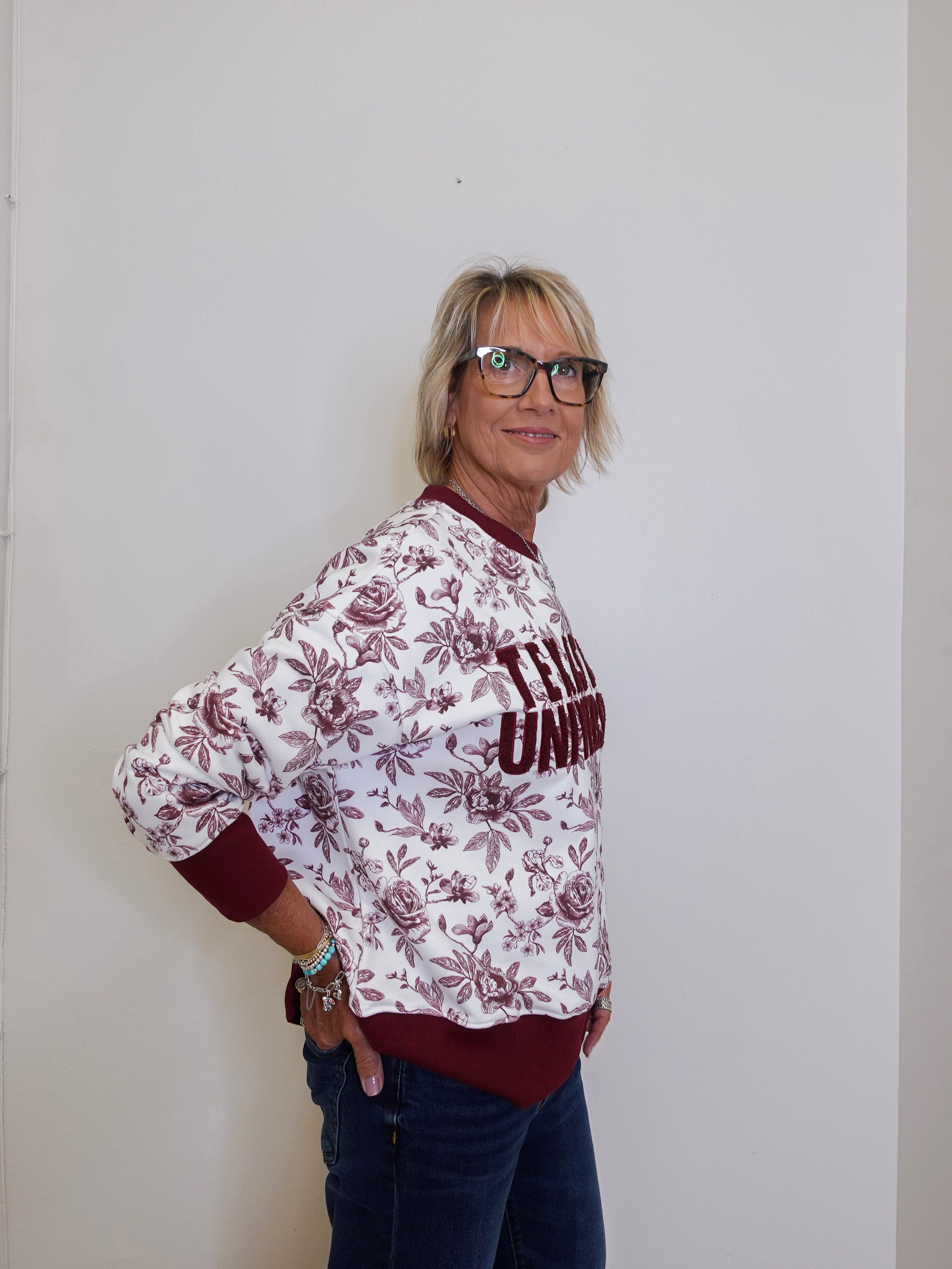 Person wearing a patterned shirt with text against a plain background