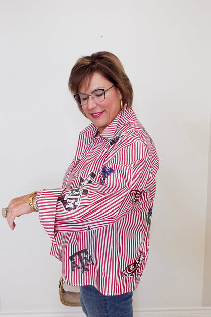 Woman wearing a red and white striped shirt with decorative elements, standing indoors.