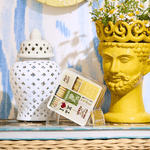 Decorative items including a yellow vase with a face, a white lantern, and a box of matches on a surface.