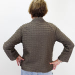 A person viewed from behind wearing a textured, ribbed brown jacket and light blue jeans against a plain white background.