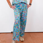 Person wearing a blue floral patterned outfit on a white background