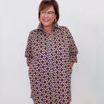 Woman wearing a patterned dress against a white background