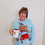 woman wearing a grandmas house knit top in blue against a white background. 