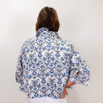 Person wearing a blue and white patterned shirt against a white background