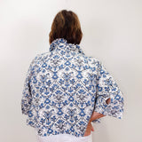 Person wearing a blue and white patterned shirt against a white background