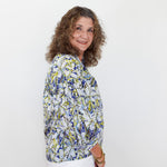 Woman wearing a patterned blouse against a white background