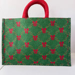Green bag with red bow pattern and red handle on a white background