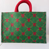 Green bag with red bow pattern and red handle on a white background