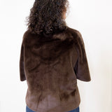 Person wearing a brown fur jacket on a white background